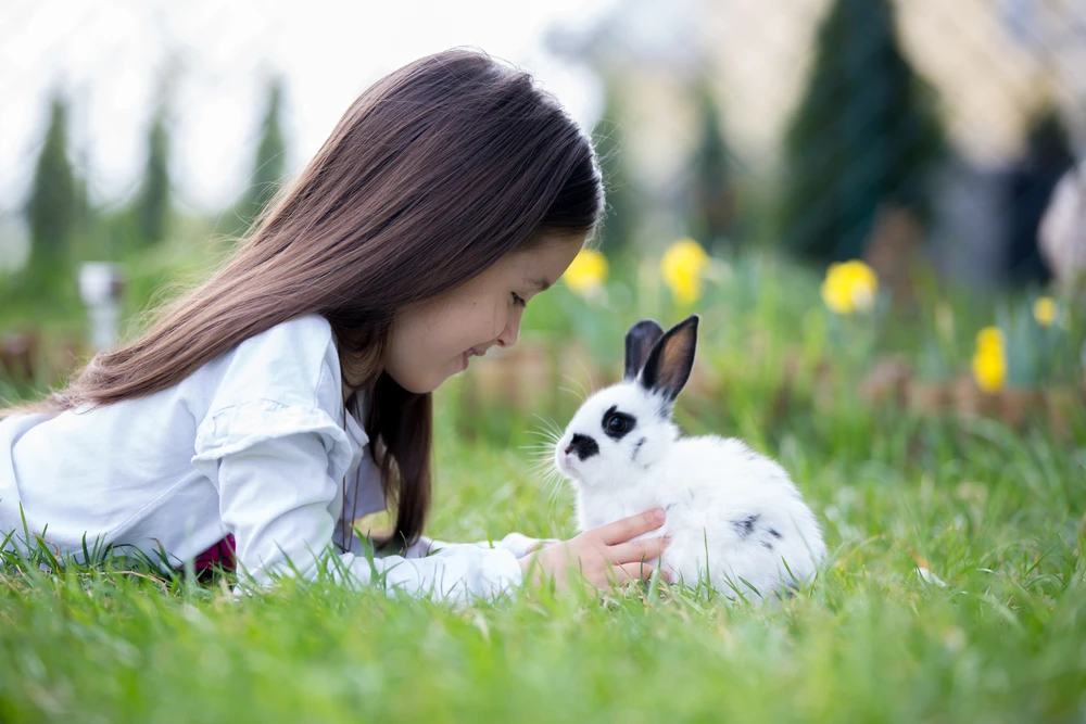 Meisje met konijn in de tuin